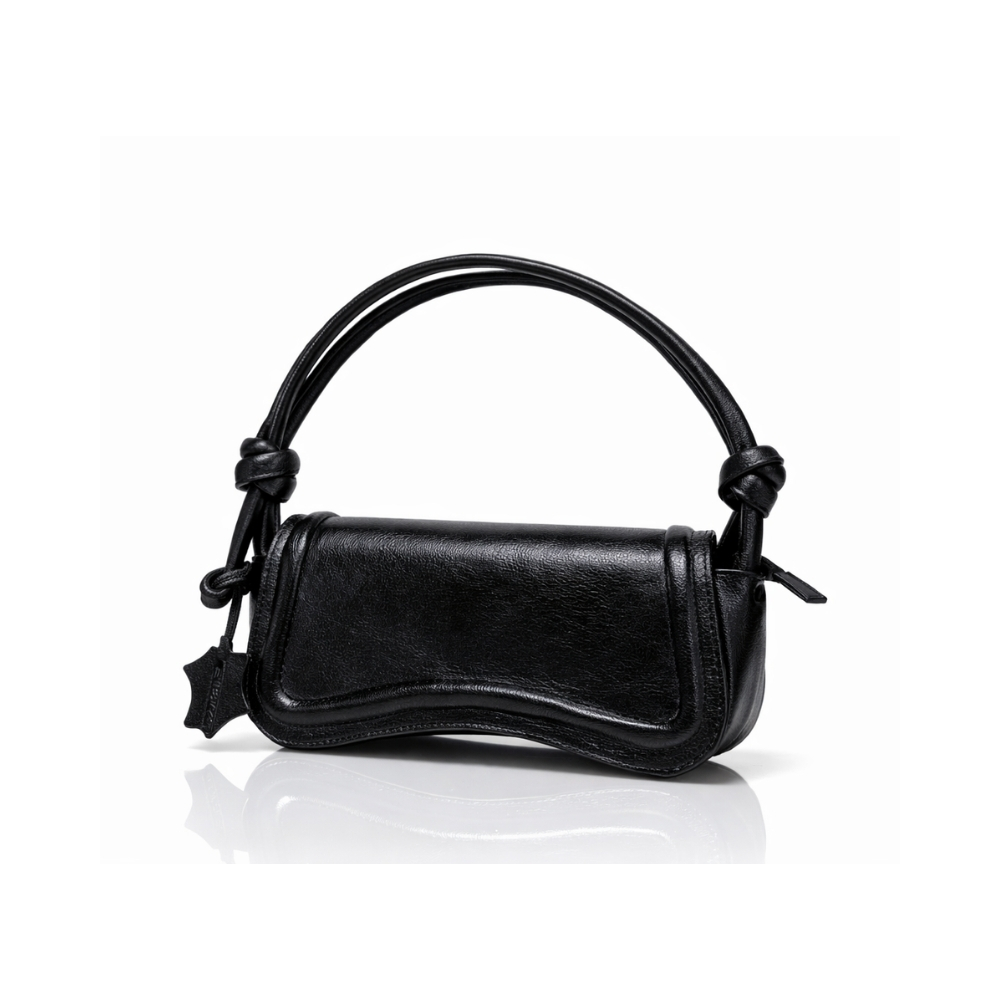 Black leather shoulder handbag with curved flap and knotted straps on white background